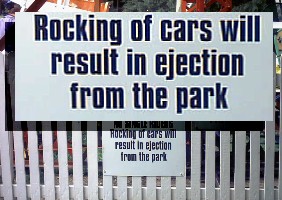 Sign beside amusement park ride: 'Rocking of cars will result in ejection from park.'