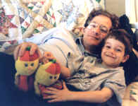 Peter & Daddy lying on the couch with two Rainbow Hectors. (150278 bytes)